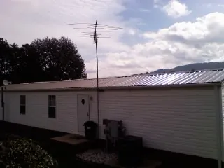New metal roof on a single wide mobile home with a TV antenna in Lorton