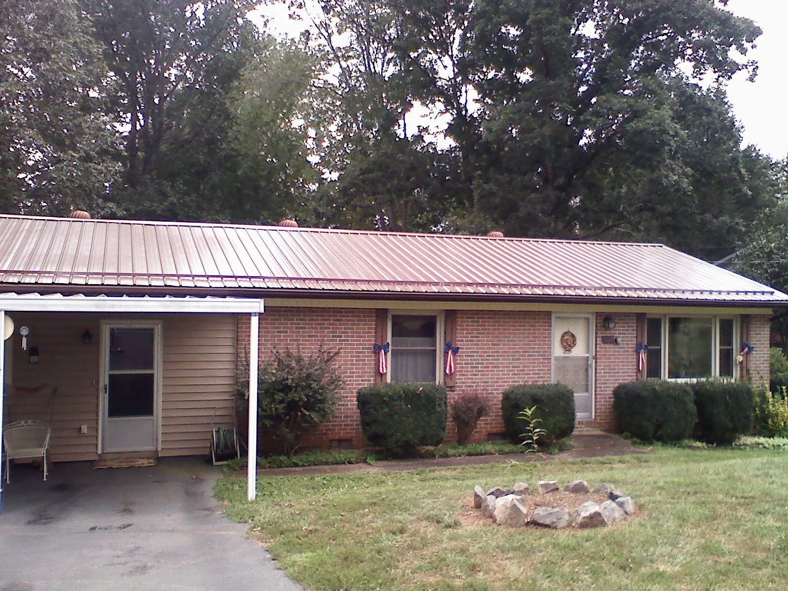 Bronze metal roof and carport on a brick ranch home — Roof Repair work by our crew in Lorton